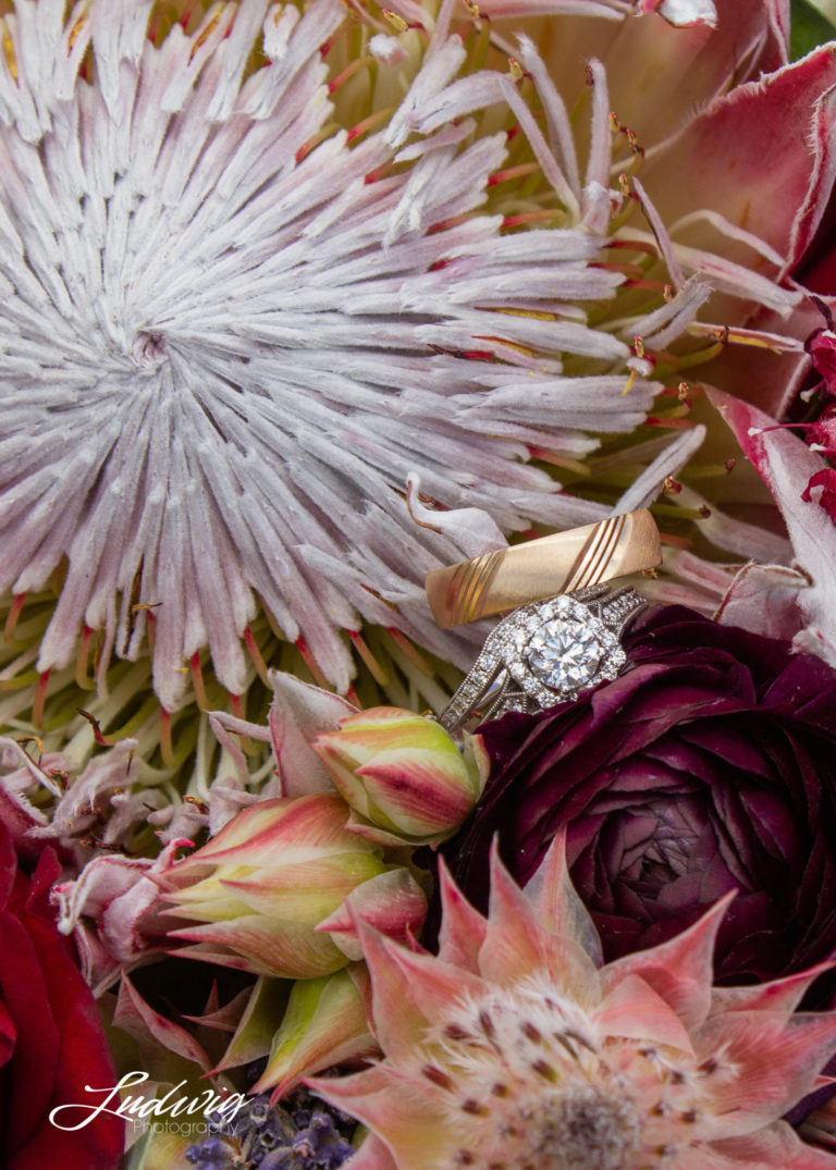 gold and silver wedding rings in bouquet of flowers