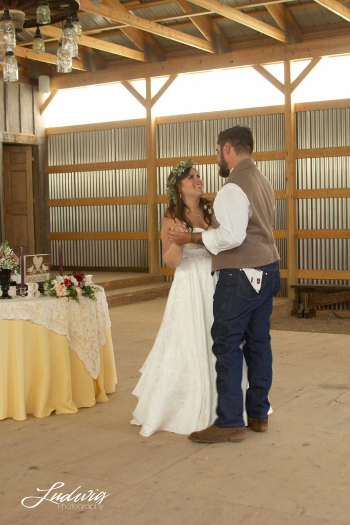 bride and groom sharing first dance in a barn wedding venue