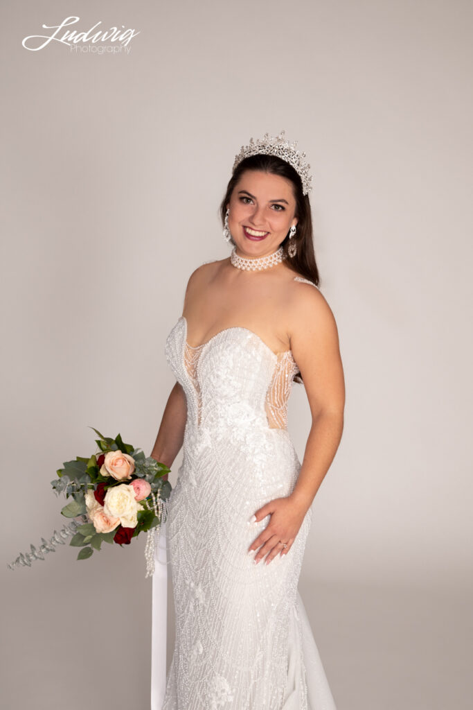 a portrait of a brunette bride looking at the camera against a white background