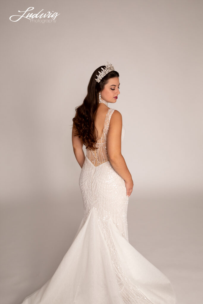 a portrait of a brunette bride looking at the camera against a white background