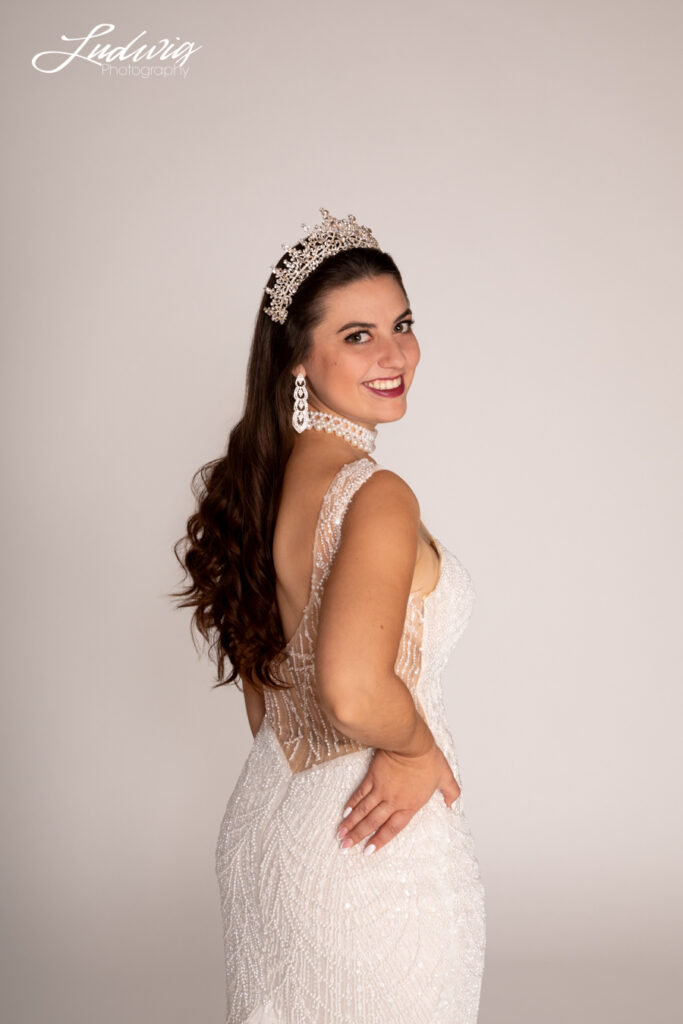 a portrait of a brunette bride looking at the camera against a white background