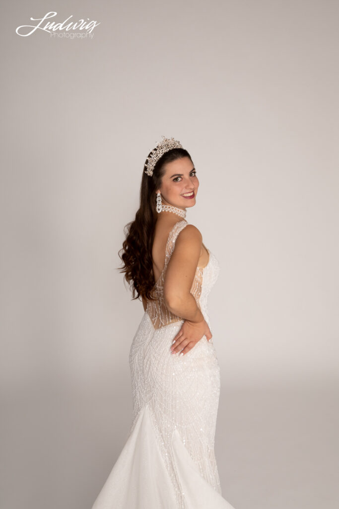 a portrait of a brunette bride looking at the camera against a white background