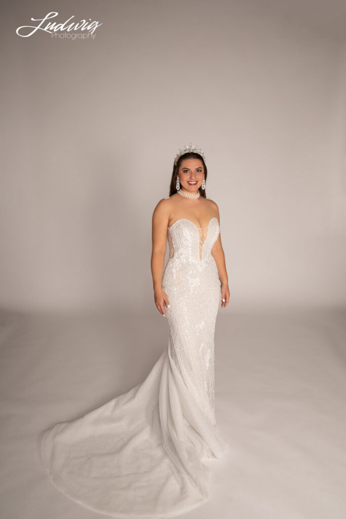 a portrait of a brunette bride looking at the camera against a white background