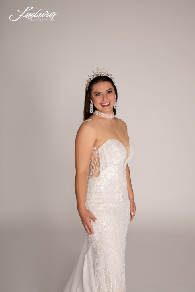 a portrait of a brunette bride looking at the camera against a white background