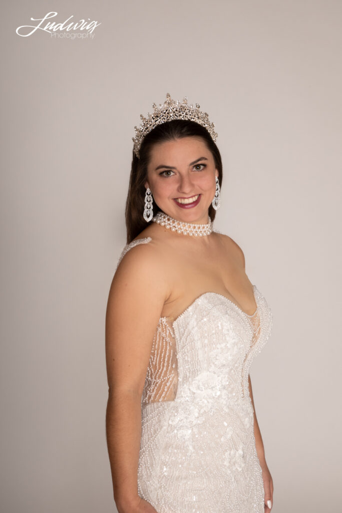 a portrait of a brunette bride looking at the camera against a white background