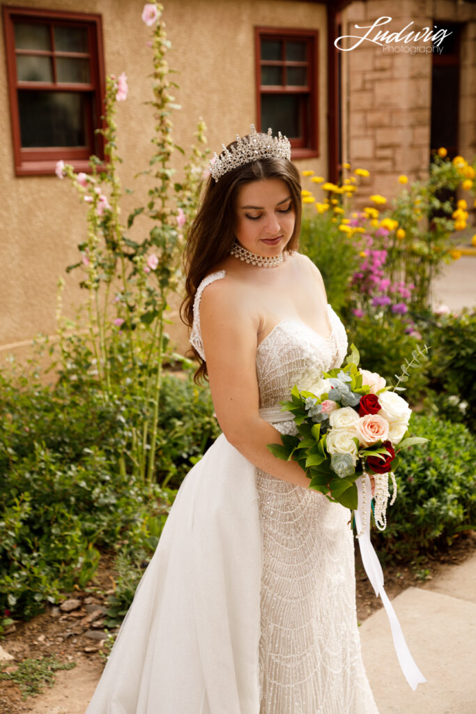 an outdoor portrait of a brunette bride in a wedding gown with a natural garden background