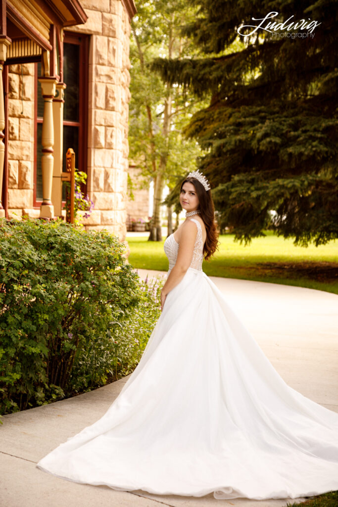 an outdoor portrait of a brunette bride in a wedding gown with a natural garden background