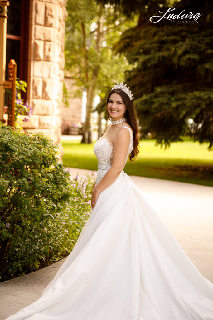 an outdoor portrait of a brunette bride in a wedding gown with a natural garden background