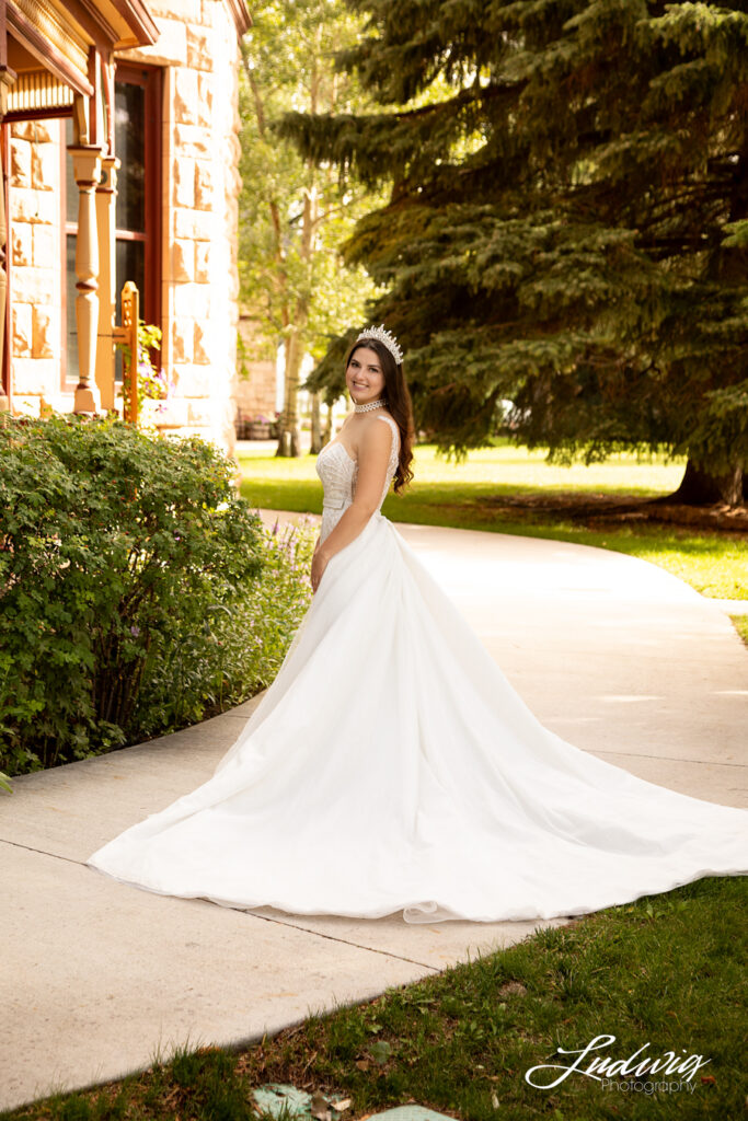 an outdoor portrait of a brunette bride in a wedding gown with a natural garden background