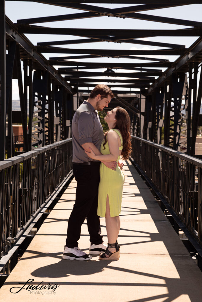 a young couple smiling and having fun outdoors in Wyoming at the footbridge in downtown laramie wyoming