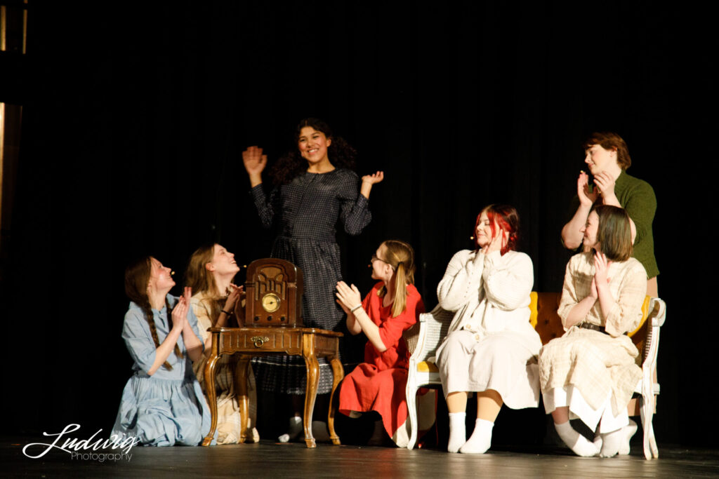 Orphans gathered close to a radio on stage