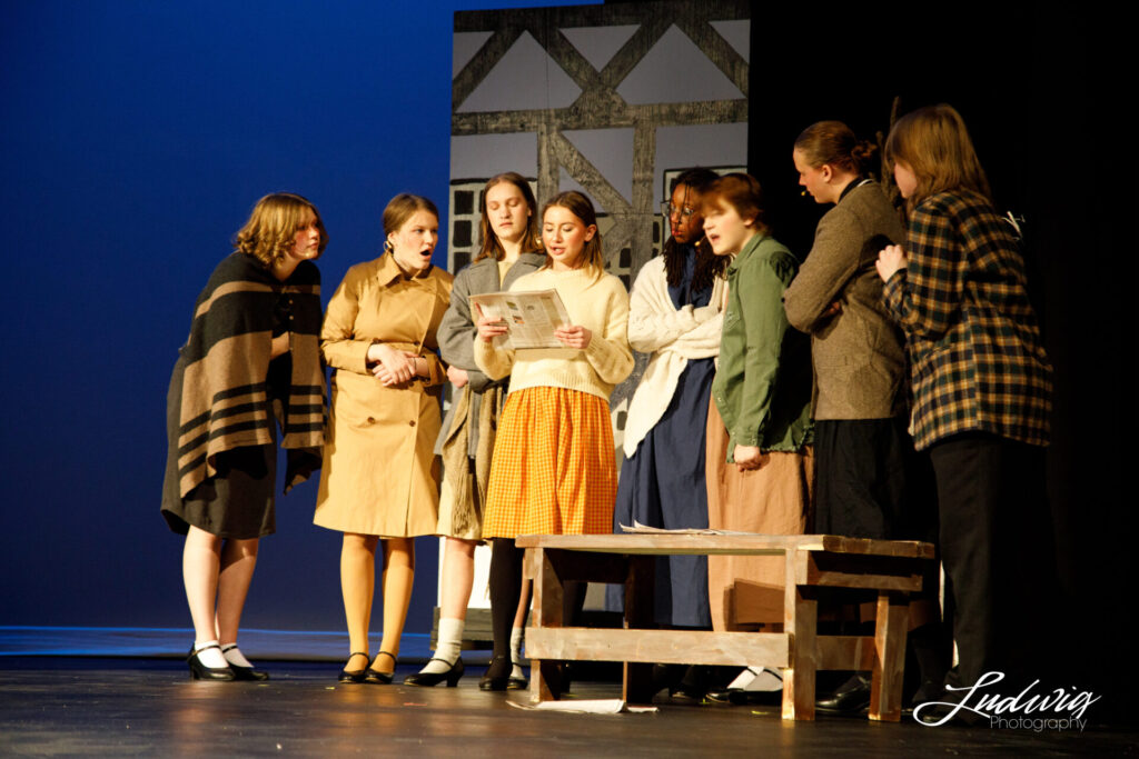 A group of actors on stage during a high school musical adaptation of Annie