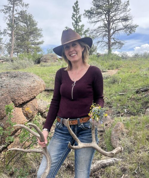 Portrait of Anne Brande, Wyoming fourth-generation Photographer at Ludwig in Laramie Wyoming, holding antlers outdoors